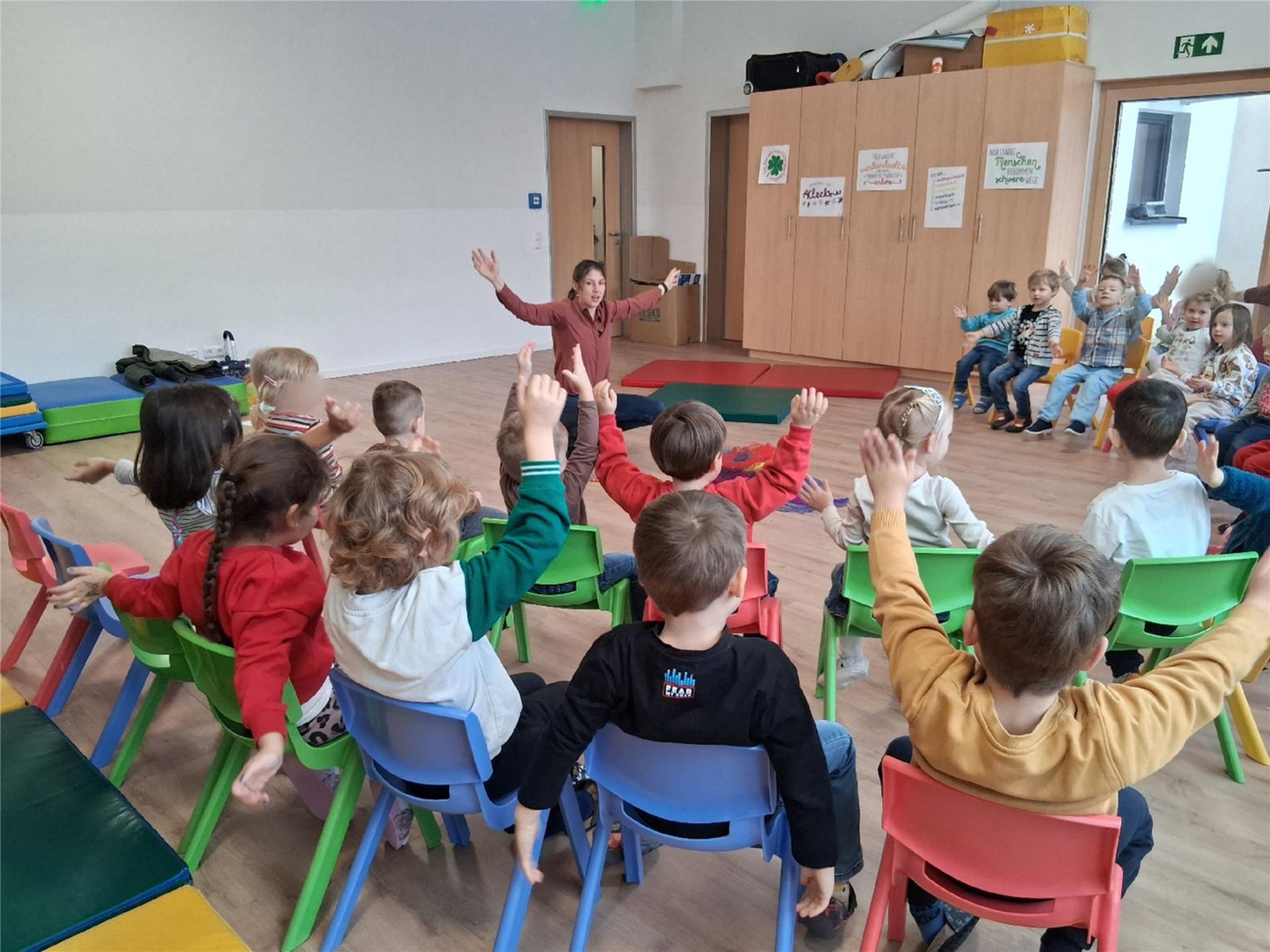 Kinder legen ein Kreuz aus Tüchern in einem Gruppenraum und feiern gemeinsam mit Gemeindereferentin Barbara Maier den Aschermittwoch.